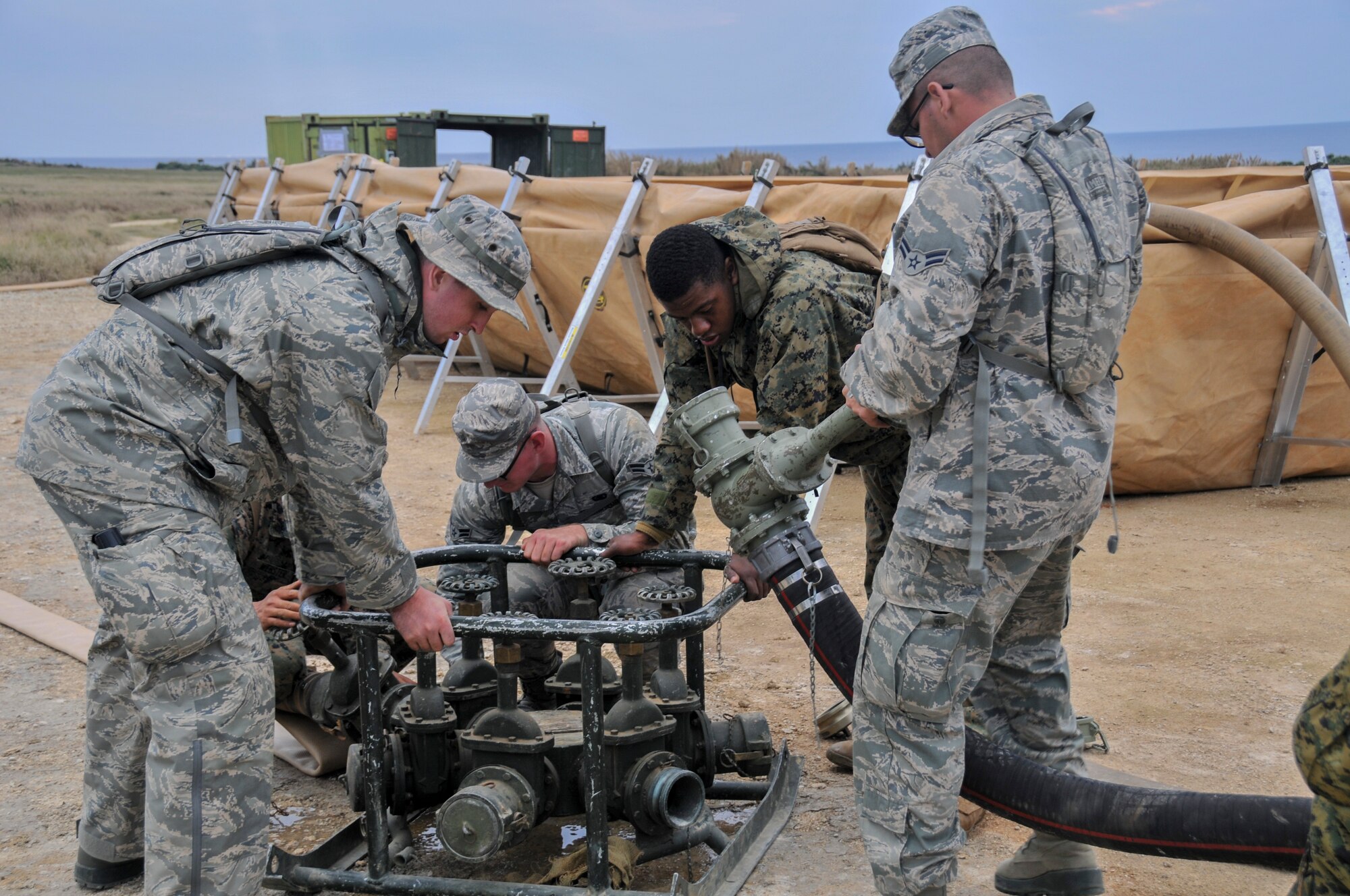 U.S. Marine Corps engineers assigned to the 9th Engineer Support Battalion and Airmen from the 18th Logistics Readiness Squadron assemble an amphibious assault fuel system Jan. 27, 2016, during an exercise on the island of Ie Shima off the coast of Okinawa, Japan. The mission was to conduct simulated bulk petroleum operations around Ie Shima in order to validate AAFS embarkation requirements, deployment timelines and refine standard operating procedures. (Courtesy photo)