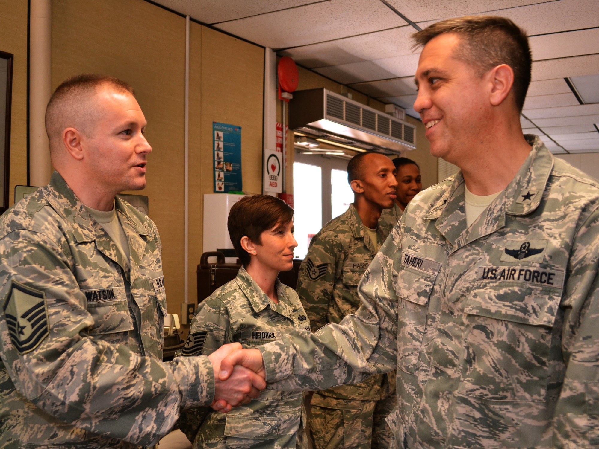 Brig. Gen. Michael R. Taheri, the Commander of the Air National Guard Readiness Center, Joint Base Andrews, Maryland, coins members of the 111th Force Support Squadron in the dining facility at Horsham Air Guard Station, Pa., March 12, 2016. Most of Taheri’s visit was spent talking with the Guardsmen here and recognizing their service by presenting coins to exceptional members. (U.S. Air National Guard photo by Tech. Sgt. Andria Allmond)