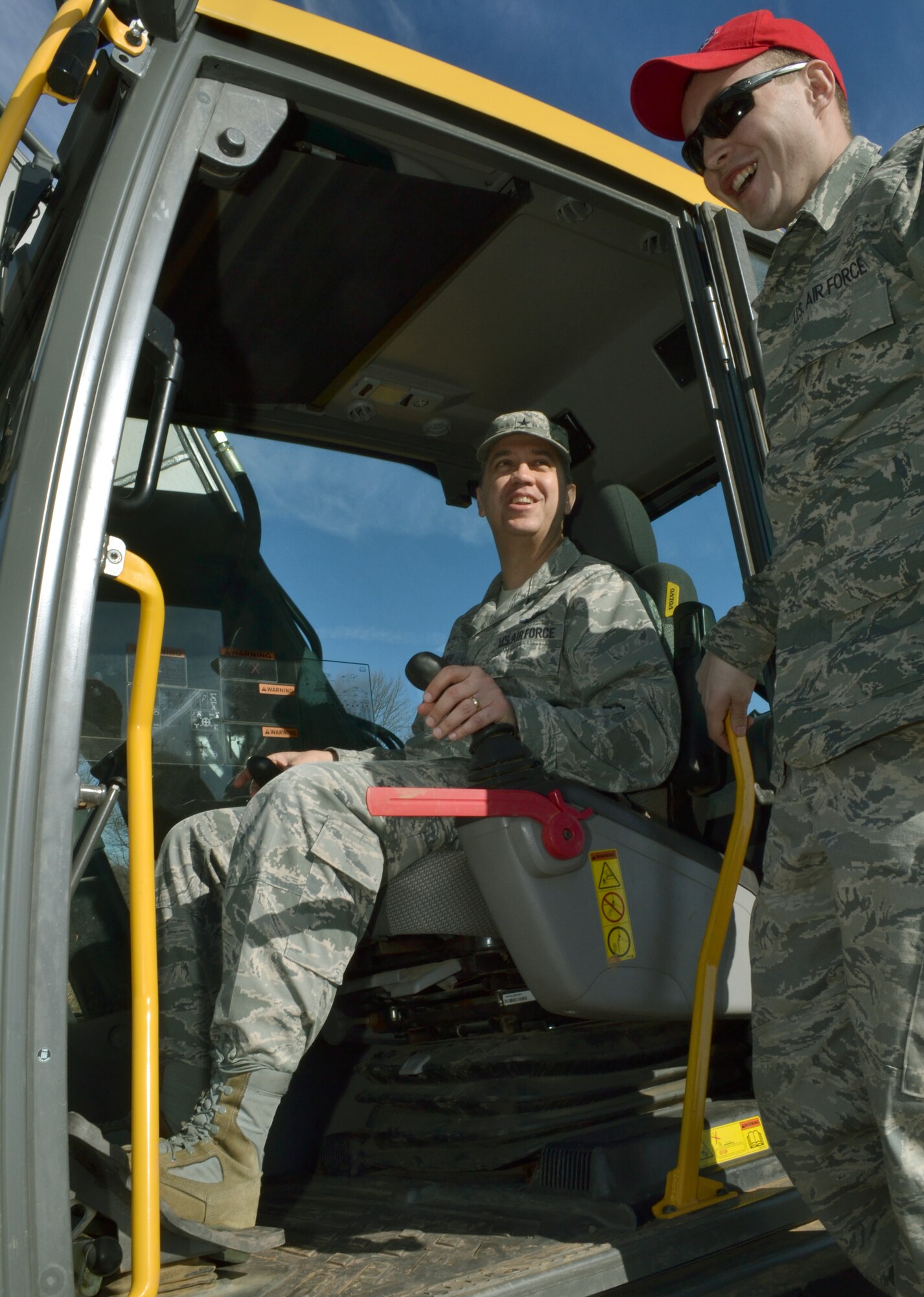 Brig. Gen. Michael R. Taheri, the Commander of the Air National Guard Readiness Center, Joint Base Andrews, Maryland, sits inside an excavator while Senior Airman Anthony Masser, of the 201st RED HORSE, Det. 1, explains the controls in a training area at Horsham Air Guard Station, Pa., March 12, 2016. Taheri received a hands-on tour throughout the installation, seeing and experiencing the various career fields of members stationed here. (U.S. Air National Guard photo by Tech. Sgt. Andria Allmond)
