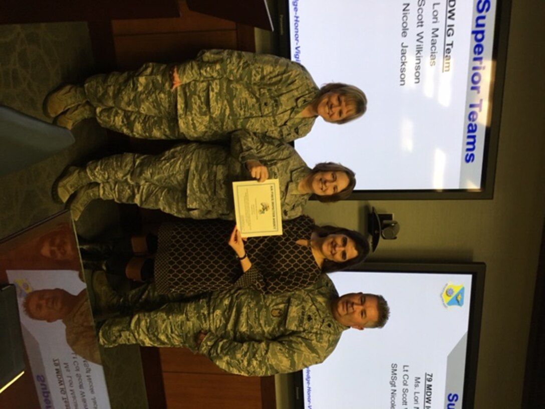 Col. Wendy J. Beal, Inspector for the Air Force Inspection Agency presents a certificate for Superior Performance to 79th Medical Wing Inspector General Office.  From left to right are Senior Master Sgt. Nicole Jackson, Mrs. Lori Macias, and Lt. Col. Scott Wilkinson.(U.S. Air Force Photo by Tech. Sgt. Jillian Kozub/released)
