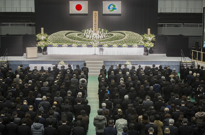 A crowd of mourners wait for the start of the 5th Kesennuma City memorial ceremony remembering all those that were lost in the Great East Japan earthquake, tsunami and nuclear disaster March 11 in Kesennuma City. Col. Roger J. McFadden represented Marine Forces Japan who responded to the disaster as a part of Operation Tomodachi. McFadden along with city representatives and Kesennuma residents placed flowers on the memorial and observed a moment of silence at 2:46 p.m. Japan Standard Time. (U.S. Marine Corps photo by Sgt. Royce Dorman)