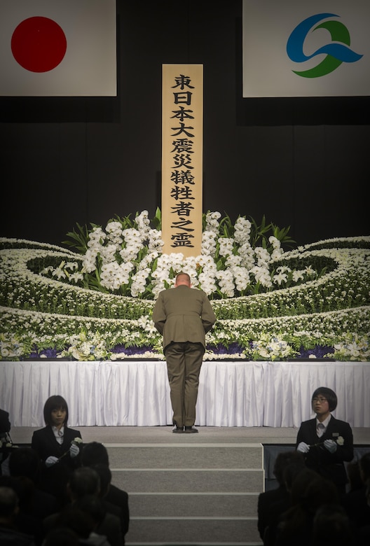 Col. Roger J. McFadden bows in front of the memorial before placing a flower in honor of those who died and were lost during the Great East Japan earthquake, tsunami and nuclear disaster March 11, in Kesennuma City. McFadden represented Marine Forces Japan who responded to the disaster as a part of Operation Tomodachi five years ago. McFadden along with city representatives and Kesennuma residents placed flowers on the memorial and observed a moment of silence at 2:46 p.m. Japan Standard Time. (U.S. Marine Corps photo by Sgt. Royce Dorman)