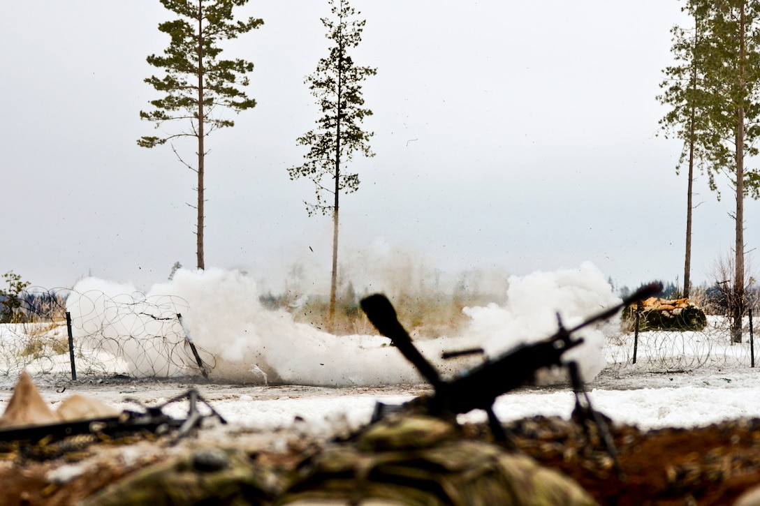 Soldiers find cover behind a berm as a breach team sets off an explosive device during a live-fire exercise at Tapa Training Area in Estonia, March 12, 2016. Army photo by Staff Sgt. Steven M. Colvin