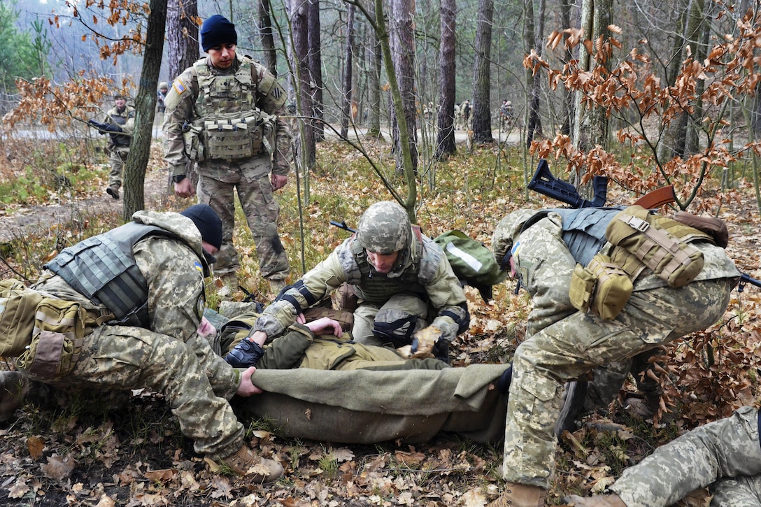 A U.S. soldier, standing, teaches Ukrainian soldiers how to conduct tactical combat casualty care during medical training at the International Peacekeeping and Security Center near Yavoriv, Ukraine, March 4, 2016. Army photo by Staff Sgt. Adriana M. Diaz-Brown