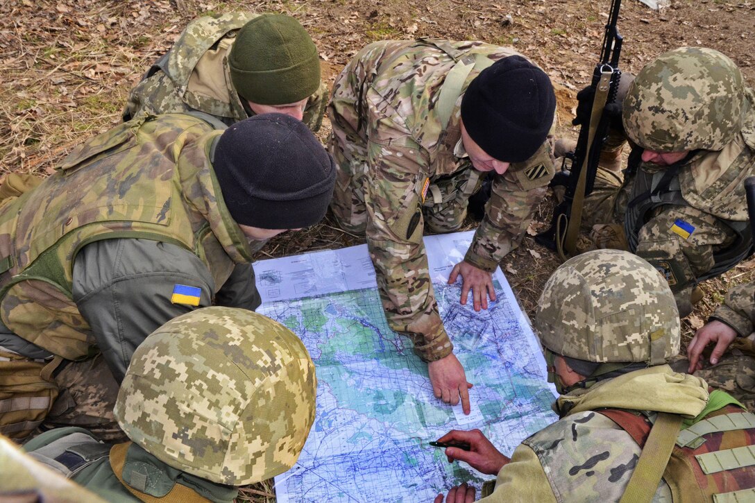 U.S. Army Staff Sgt. Curtis Chancey, center, teaches Ukrainian soldiers how to determine grid coordinates and points on a map during a map reading and land navigation class at the International Peacekeeping and Security Center near Yavoriv, Ukraine, March 5, 2016. Chancey is an infantryman assigned to the 3rd Infantry Division’s 3rd Battalion, 15th Infantry Regiment, 2nd Infantry Brigade Combat Team. Army photo by Staff Sgt. Adriana M. Diaz-Brown