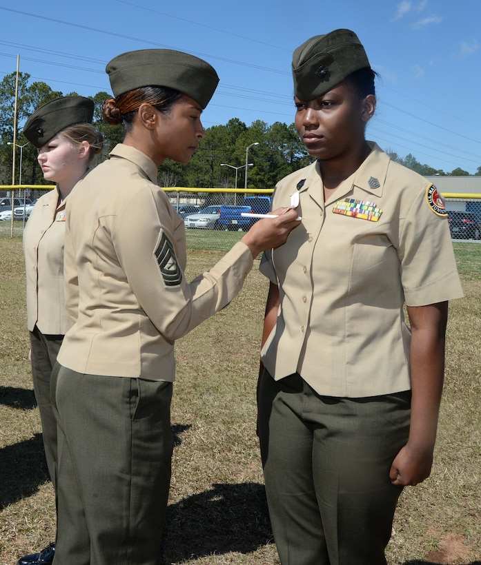 Msgt. Desarie Newman, operations chief, LOGCOM, measures the placement of rank on a cadets’ uniform during an annual Marine Corps Junior Reserve Officer Training Course inspection at Westover High School recently.