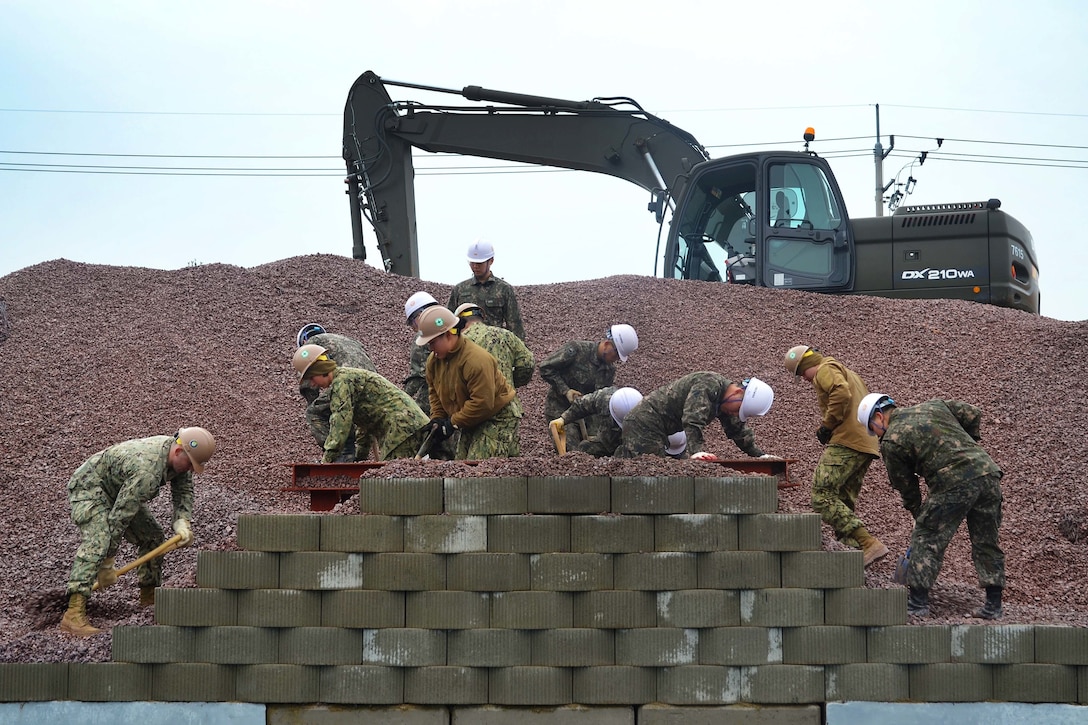 U.S. and South Korean sailors clear gravel out of a steel structure to deconstruct a mobile training pier during Exercise Foal Eagle 2016 in Chinhae, South Korea, March 8, 2016. The U.S. sailors are Seabees assigned to Naval Mobile Construction Battalion 4. Navy photo by Petty Officer 3rd Class Christian Konn