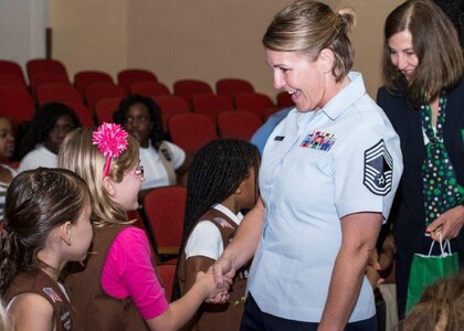 Chief Master Sgt. Katie McCool, 502nd Security Forces and Logistics Group superintendent, shakes the hand of Emily Sealock, a member of the Girl Scouts of Southwest Texas Randolph Service Unit, during the annual Girl Scouts retreat flag ceremony March 8 in the Joint Base San Antonio-Randolph Fleenor Auditorium. This event is held each year in honor of American heritage as well as the first Girl Scout meeting in 1912. McCool spoke to the girls about her experiences as a female Airman, the importance of using their lives to make a difference in the world and their worth as young women.