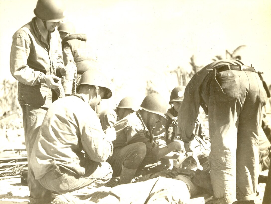 Okinawa, Japan, April-May 1945. Marines and Corpsmen provide medical attention to a wounded Marine.