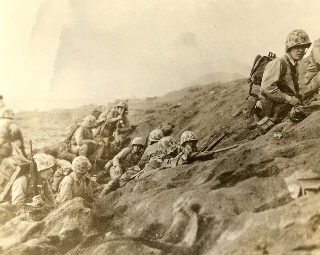 Fourth Marine Division, Iwo Jima, Japan, Feb 1945. Marines prepare to move off the landing beach and advance inland. The top of Mount Suribachi is just visible in the background. 