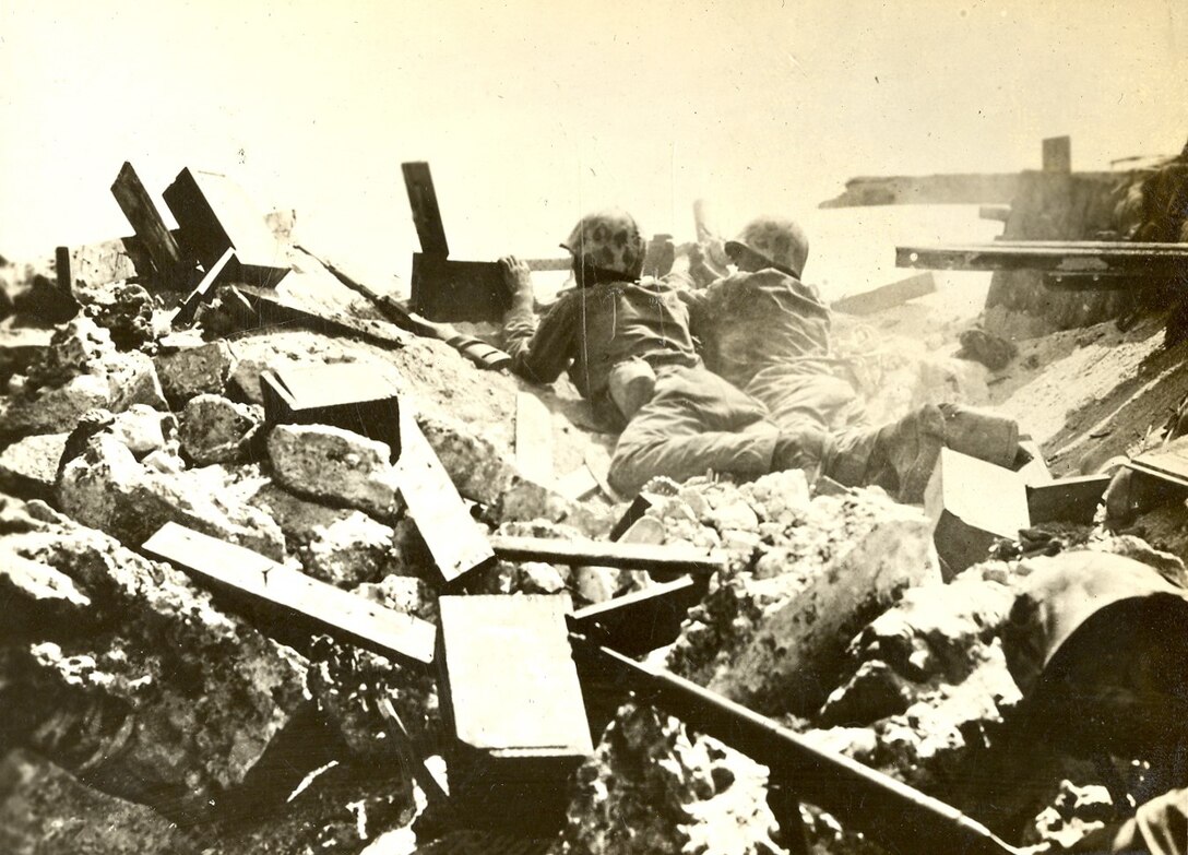 Okinawa, Japan, April-May 1945. A machinegun crew put rounds downrange from a concealed position. Additional Marines guard the machinegun team’s position.