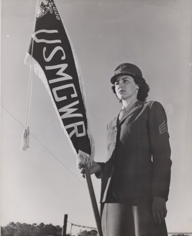 Sergeant Virginia Arms-Mill, Camp Lejeune, USMCWR, NC, c. 1944. Serving in the U.S. Marine Corps Women’s Reserve, she holds the “Bulldog Platoon” guide-on, awarded for best demonstration of trick-drill at a weekly regimental review.