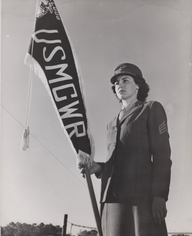 Sergeant Virginia Arms-Mill, Camp Lejeune, USMCWR, NC, c. 1944. Serving in the U.S. Marine Corps Women’s Reserve, she holds the “Bulldog Platoon” guide-on, awarded for best demonstration of trick-drill at a weekly regimental review.