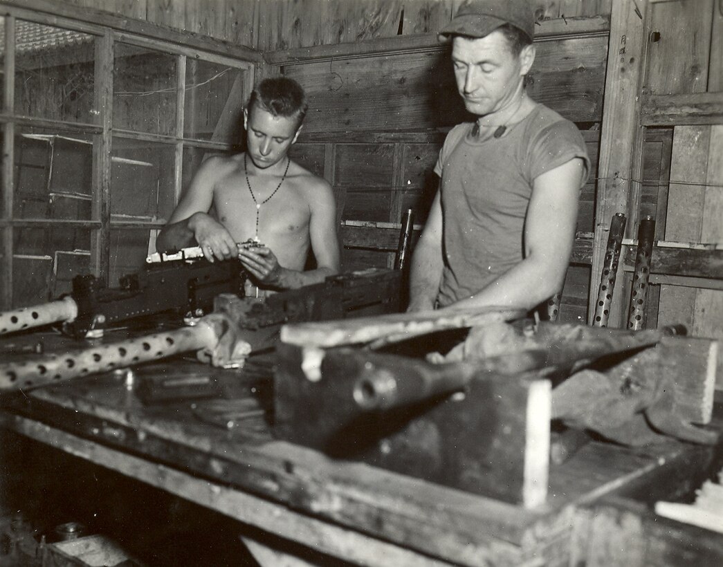 33rd Marine Aircraft Group, Okinawa, Japan, April-May 1945. Marines maintenance and prepare aircraft armament, .50 caliber machineguns, for Marine aircraft.