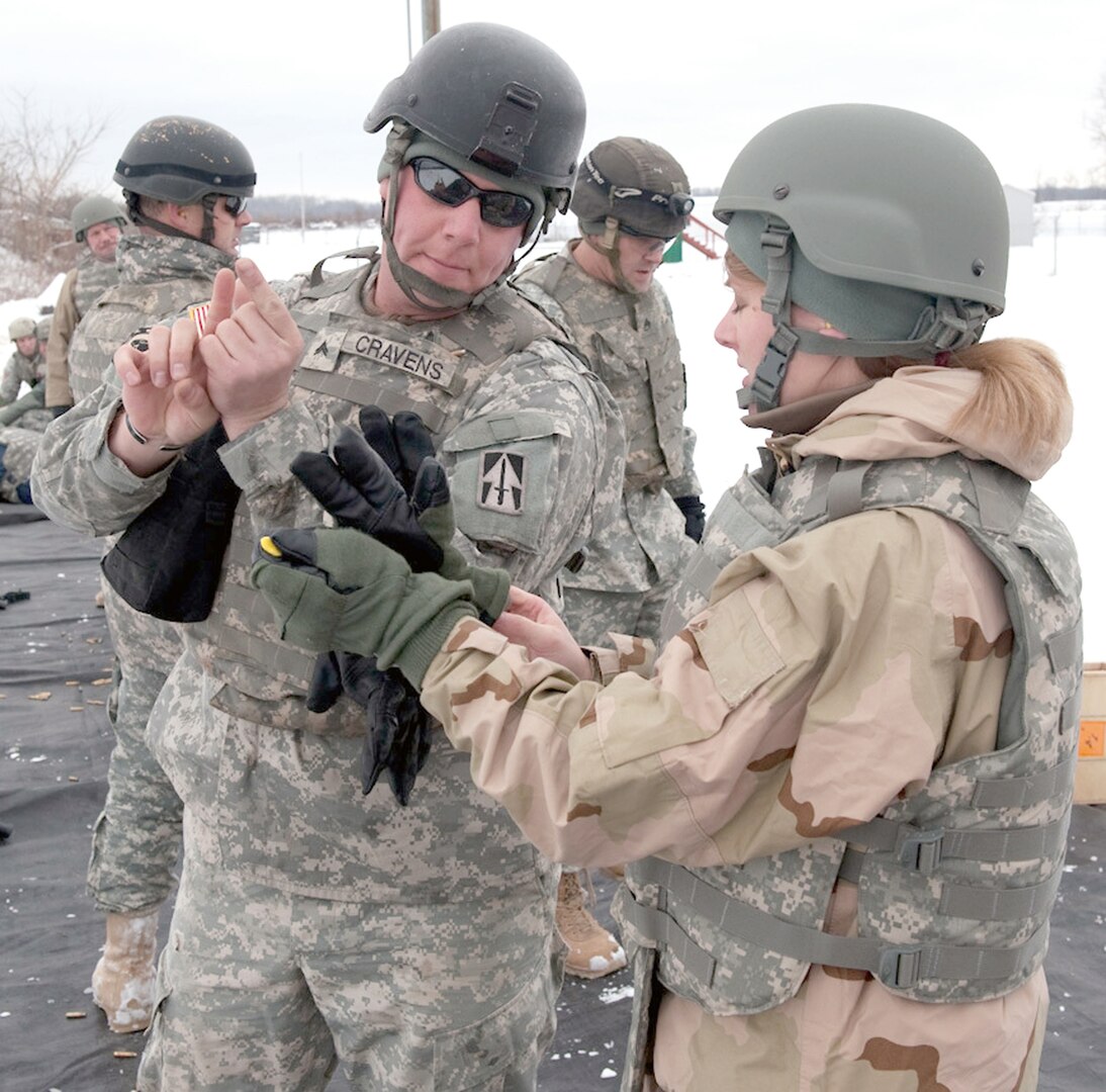 Cpl. Kevin Cravens, with the Range Training Team at Camp Atterbury Joint Maneuver Training Center, Ind., explains how to aim an M4 carbine to Anne Williams of the Civilian Expeditionary Workforce at Camp Atterbury Dec. 16. Part of the CEW's training included weapons familiarization with the M4 carbine and M9 9mm pistol.