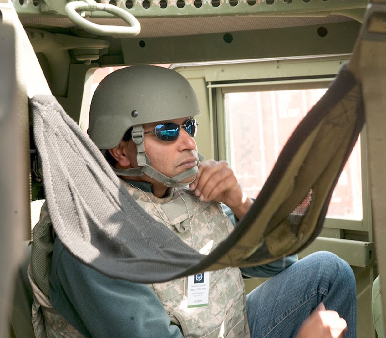 Yatradeo Coomar, a budget analyst with Navel Entitlements, adjusts his Kevlar helmet prior to departing in a convoy from Combat Outpost Panther at Muscatatuck Urban Training Center, Ind. Oct. 18. Coomar was at Muscatatuck with the Civilian Expeditionary Workforce and is embarking on his first deployment to Djibouti, Africa.