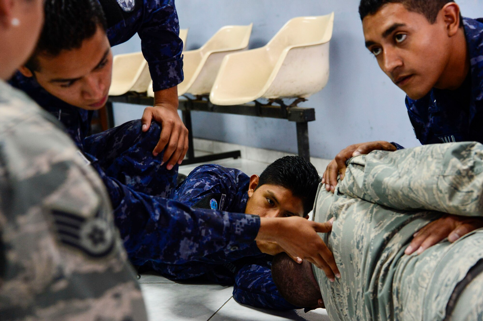 U.S. Air Force Staff Sgt. Karina Cortes and Senior Airman Jacob Radford, 628th Medical Operations Squadron medical technicians, take a group of Salvadoran air force members through self-aid buddy care exercises during a medical subject matter expert exchange at Ilopango Air Base, El Salvador, March 9, 2016. 12th Air Force (Air Forces Southern) surgeon general’s office, led a five-member team of medics from around the U.S. Air Force on a week-long medical subject matter expert exchange in El Salvador. (U.S. Air Force photo by Tech. Sgt. Heather R. Redman/Released)