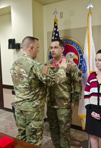 Col. Nicholas Katers, engineer officer assigned to U.S. Army Forces Command bestows Sgt. 1st Class Matthew Torres, operations noncommissioned officer with G-37, U.S. Army Reserve Command, with the Bronze de Fleury Medal at USARC headquarters, Fort Bragg, N.C., March 15, 2016. The Engineer Regiment makes three award levels of the de Fleury Medal. The Bronze medal is presented to an individual who has rendered significant support or service to more than one element of the Engineer Regiment. The award is normally presented for service that exceeds ten years.(U.S. Army Reserve photo by  Brian Godette, USARC Public Affairs)