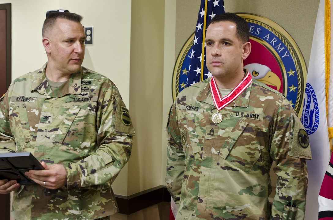 Col. Nicholas Katers, engineer officer assigned to U.S. Army Forces Command, presents Sgt. 1st Class Matthew Torres, operations noncommissioned officer with G-37, U.S. Army Reserve Command, with the Bronze de Fleury Medal at USARC headquarters, Fort Bragg, N.C., March 15, 2016. The Engineer Regiment makes three award levels of the de Fleury Medal. The Bronze medal is presented to an individual who has rendered significant support or service to more than one element of the Engineer Regiment. The award is normally presented for service that exceeds ten years.(U.S. Army Reserve photo by  Brian Godette, USARC Public Affairs)