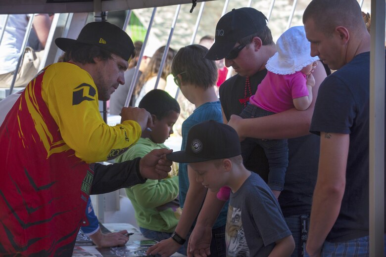 Jimmy Fitzpatrick, freestyle motocross rider, Metal Mulisha, autographs a child’s hat at the Motocross Jam Fest aboard the Combat Center March 12, 2016. The event, hosted by Marine Corps Community Services, included concession stands, motorcycle stunt performances by professional motocross riders, and live rock music from Boston-based band, Lansdowne. (Official Marine Corps photo by Lance Cpl. Levi Schultz/Released)