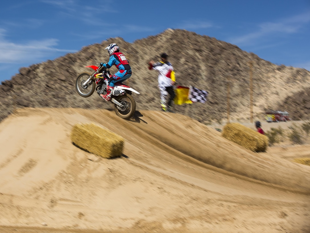 A motocross rider launches off a ramp at the Motocross Jam Fest aboard the Combat Center March 12, 2016. The event, hosted by Marine Corps Community Services, included concession stands, motorcycle stunt performances by professional motocross riders, and live rock music from Boston-based band, Lansdowne. (Official Marine Corps photo by Lance Cpl. Levi Schultz/Released)