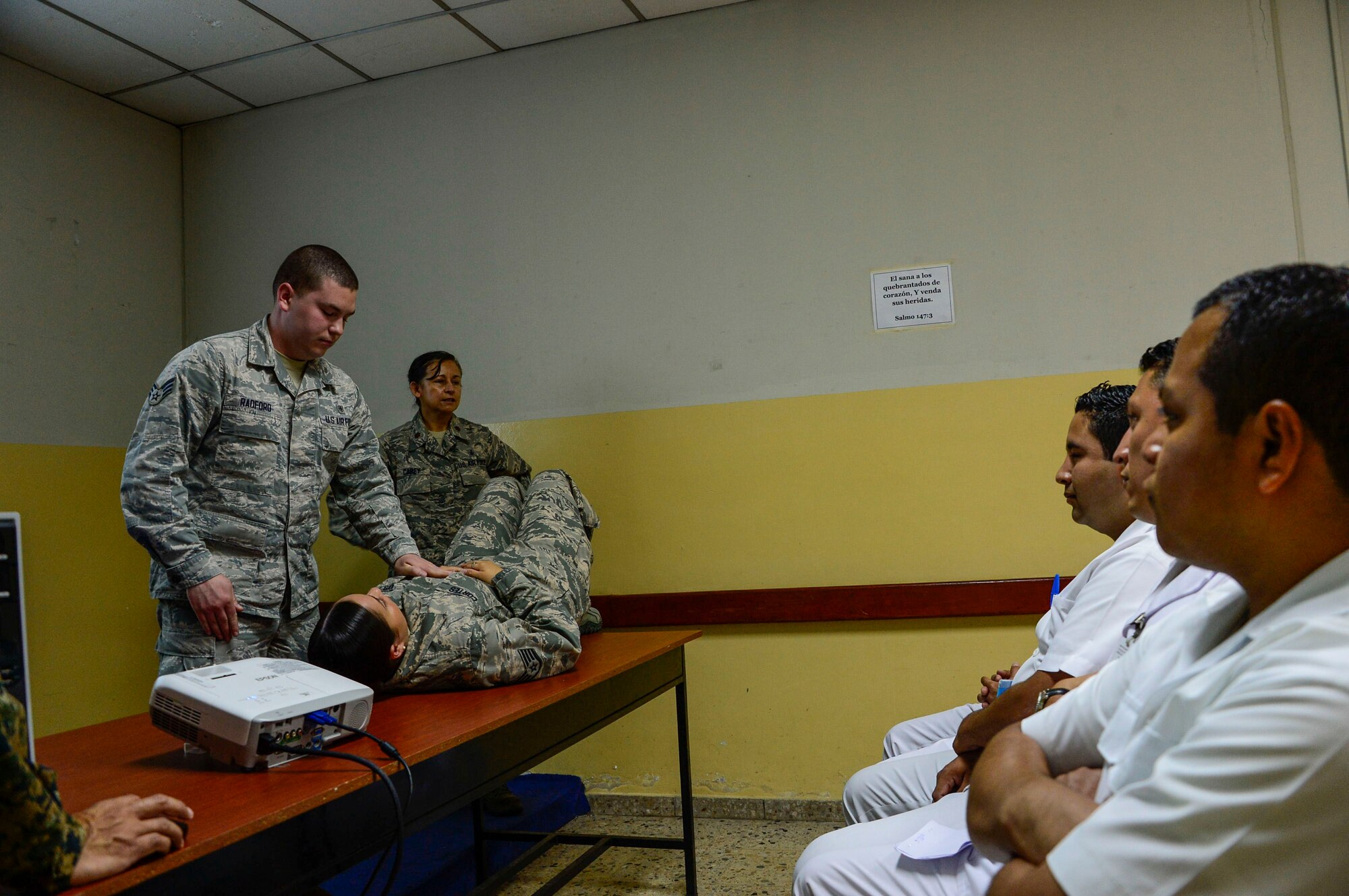 U.S. Air Force Senior Airman Jacob Radford and Staff Sgt. Karina Cortes, medical technicians stationed at Joint Base Charleston, S.C., demonstrate how to check a patient’s airway, breathing, and circulation to medical technicians in training at Hospital Militar de El Salvador during a medical subject matter expert exchange in San Salvador, El Salvador, March 11, 2016. Earlier in the week, Carey led a team of Air Force medical professionals in a week-long exchange with Salvadoran medics at Ilopango Air Base.  After the subject matter expert exchange was completed, the team was invited to a share their expertise with members of the Hospital Militar de El Salvador.  (U.S. Air Force photo by Tech. Sgt. Heather R. Redman/Released)