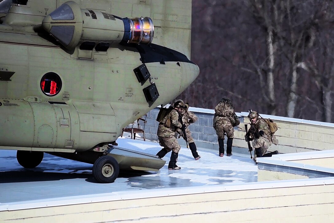 Airmen disembark from a CH-47F Chinook helicopter onto a rooftop landing zone during joint urban training on Fort Drum, N.Y., March 5, 2016. New York National Guard photo by Air Force Master Sgt. Eric Miller