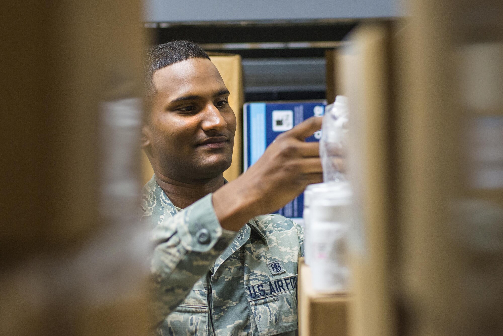 U.S. Air Force Airman 1st Class Kerraine Govia, 23d Medical Support Squadron logistics supply technician, locates the correct medication for delivery, March 15, 2016, at Moody Air Force Base, Ga. The medical logistics office maintains a variety of civilian service contracts from clinicians to medical waste management to replace deployed Airmen. (U.S. Air Force photo by Airman Daniel Snider/Released)