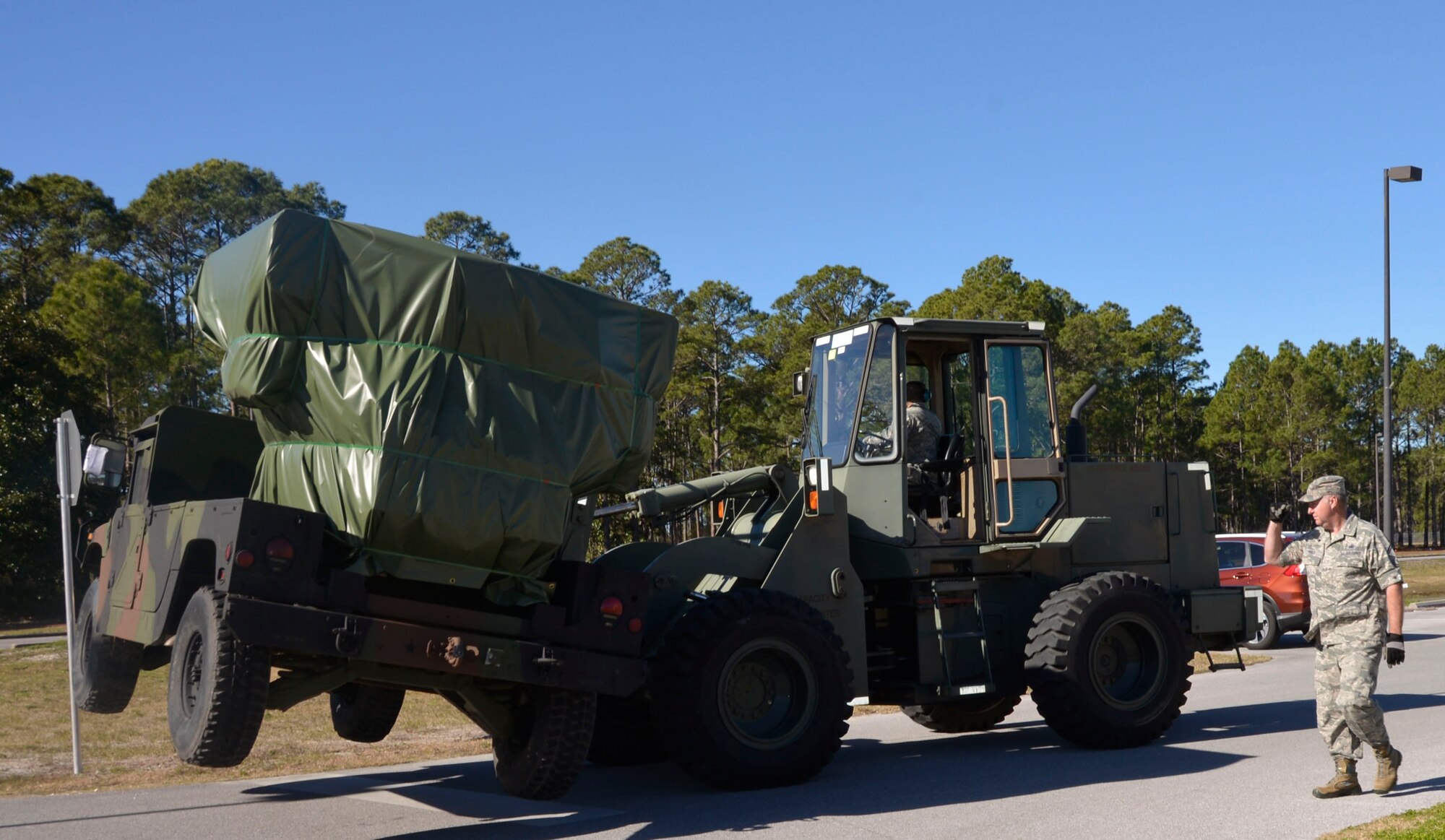 Senior Master Sgt. Johnny Pires, Air Forces Northern  Logistics Directorate, directs a forklift driver during the arrival of the Avenger Air  Defense System at the Killey Center for Homeland Operations Feb. 18. 