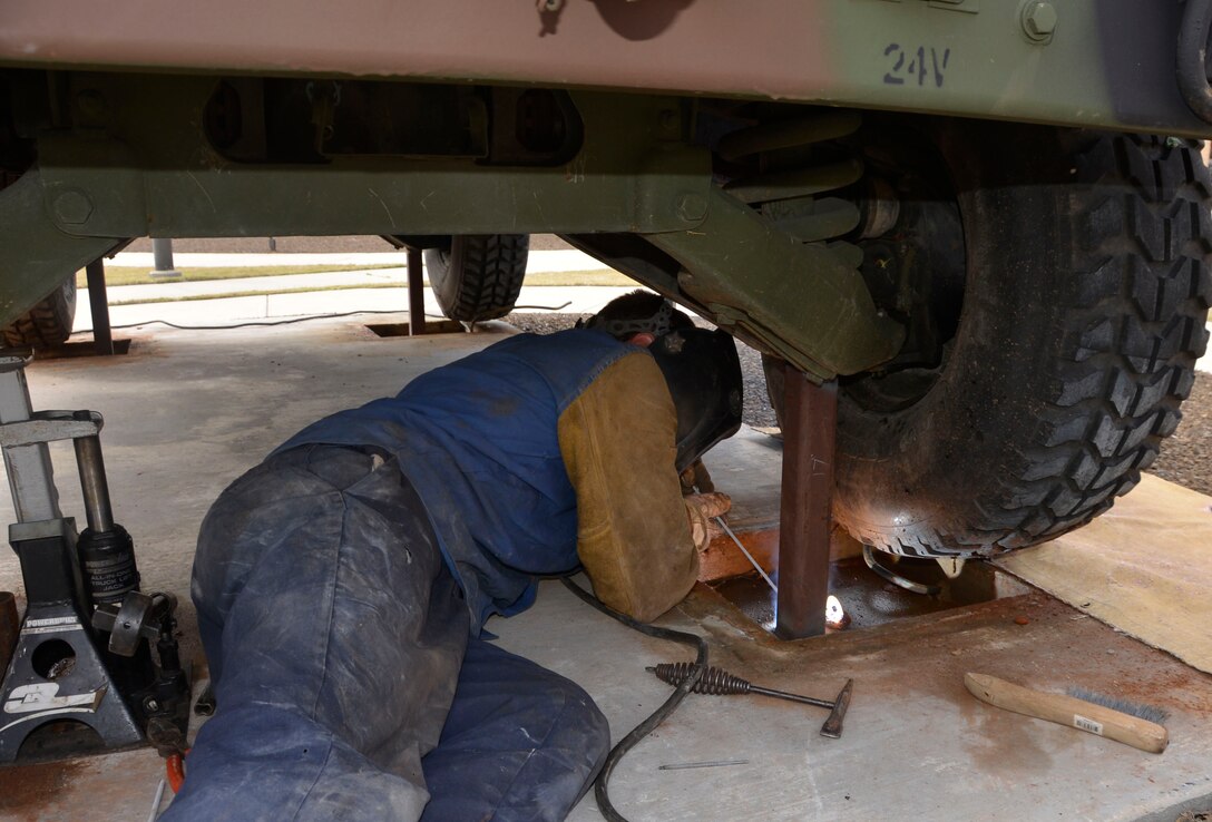 A contractor welds the chassis of the Avenger Air -Defense System to its base. 