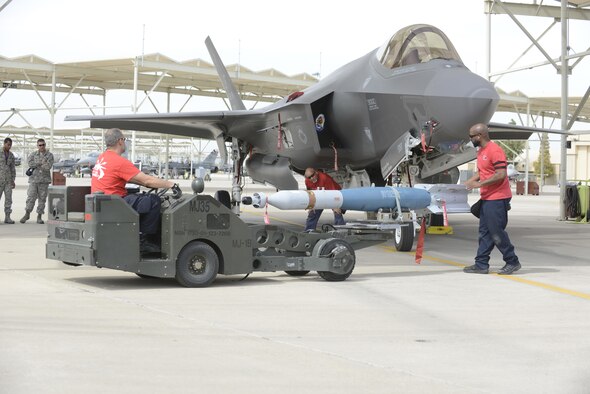 Weapons load crew members from the 62nd Aircraft Maintenance Unit load laser-guided bombs onto an F-35 Lightening II March 11, 2016 at Luke Air Force Base, Ariz. The F-35A Lightning II program took another step toward initial operational capability yesterday when two aircraft assigned to the 62nd Fighter Squadron successfully employed four laser guided bombs on the Barry M. Goldwater Range. The maintenance load crew team was comprised of Lockheed Martin contractors. (U.S. Air Force Photo by Senior Airman Devante Williams)
