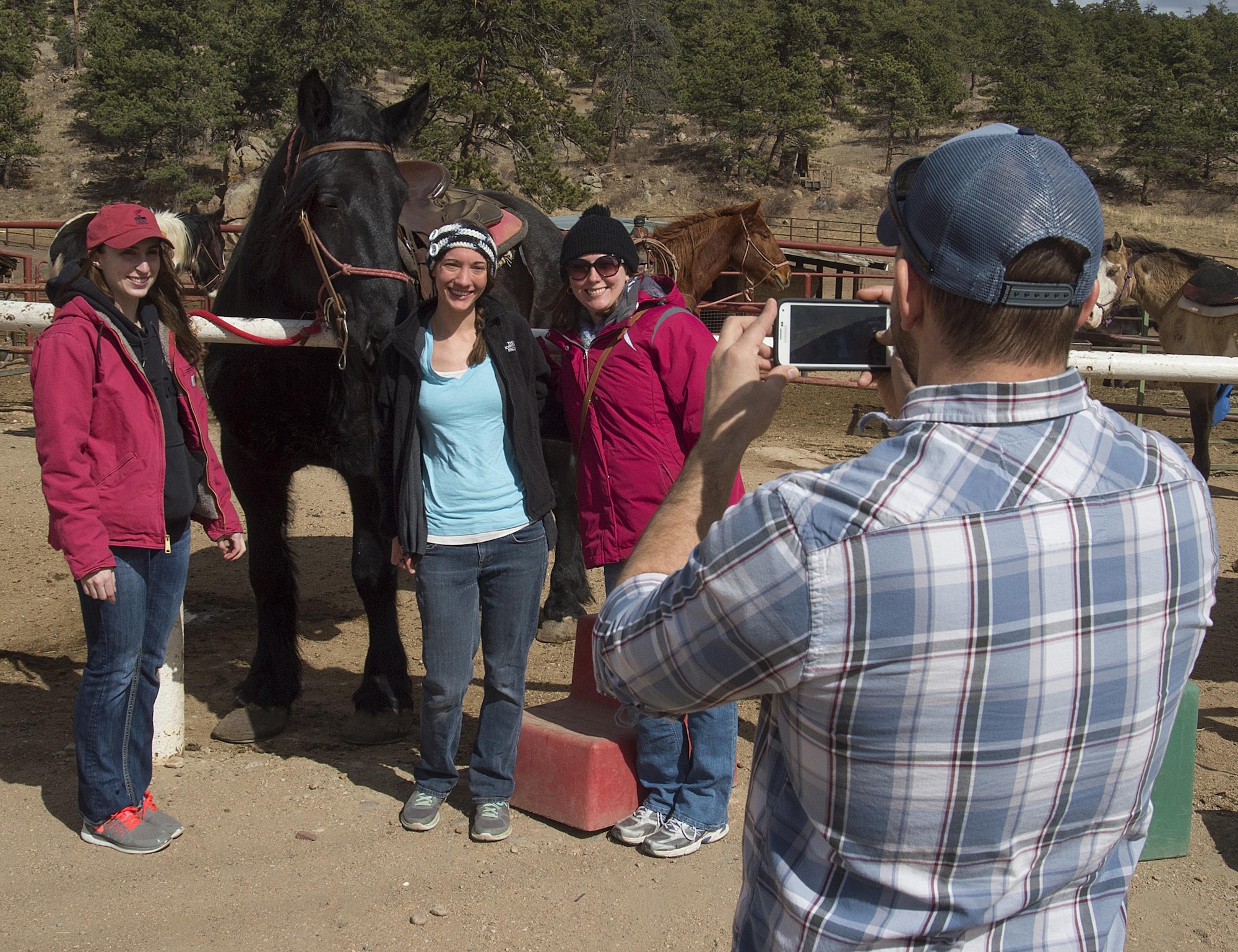 First Lt. Lindsey Byrd, 321st Missile Squadron, Brittany Lee and Cara DeYoung pose with Tracy the horse as Joe Harvey, 90th Force Support Squadron outdoors recreation, takes their picture March 13, 2016, prior to a trail ride in Estes Park, Colo. F.E. Warren Air Force Base’s Outdoor Recreation office sponsored the trip for Airmen, retirees and dependents to get a chance to ride. (U.S. Air Force photo by R.J. Oriez)