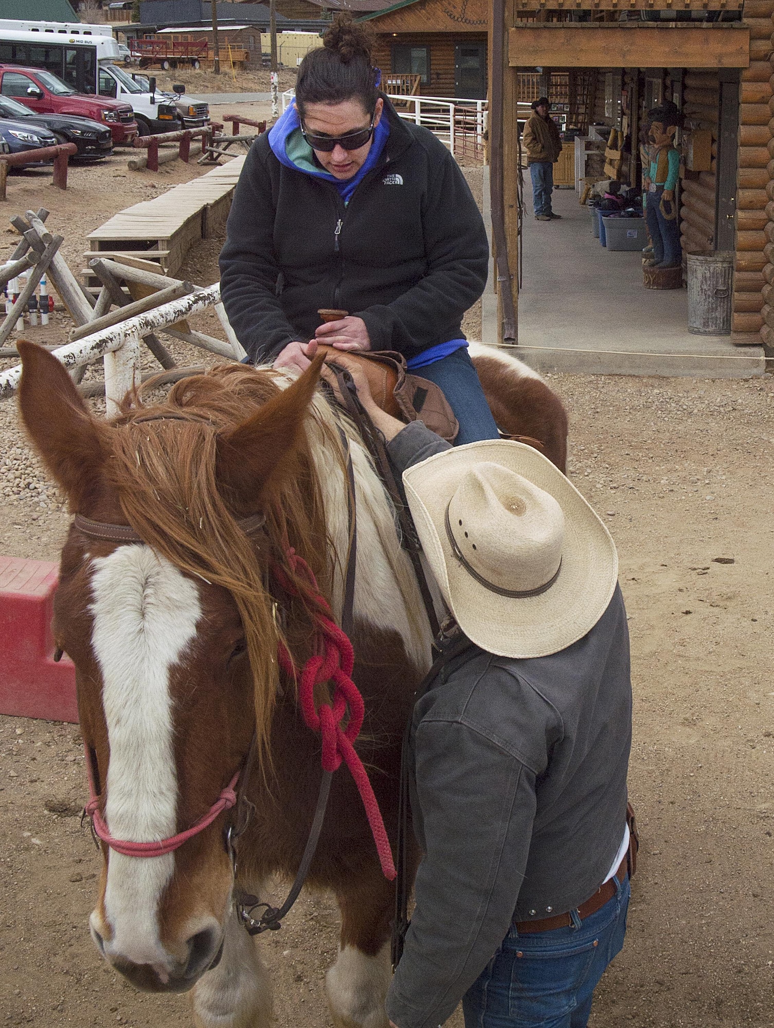 A wrangler helps 2nd Lt. Amanda Transue, 90th Medical Support Squadron, get situated onher horse March 13, 2016, before the start of a trail ride near Estes Park, Colo. Transue was part of a group of Airmen, retirees and dependents from F.E. Warren Air Force Base, Wyo., who made the trip down for a horseback ride. (U.S. Air Force photo by R.J. Oriez)