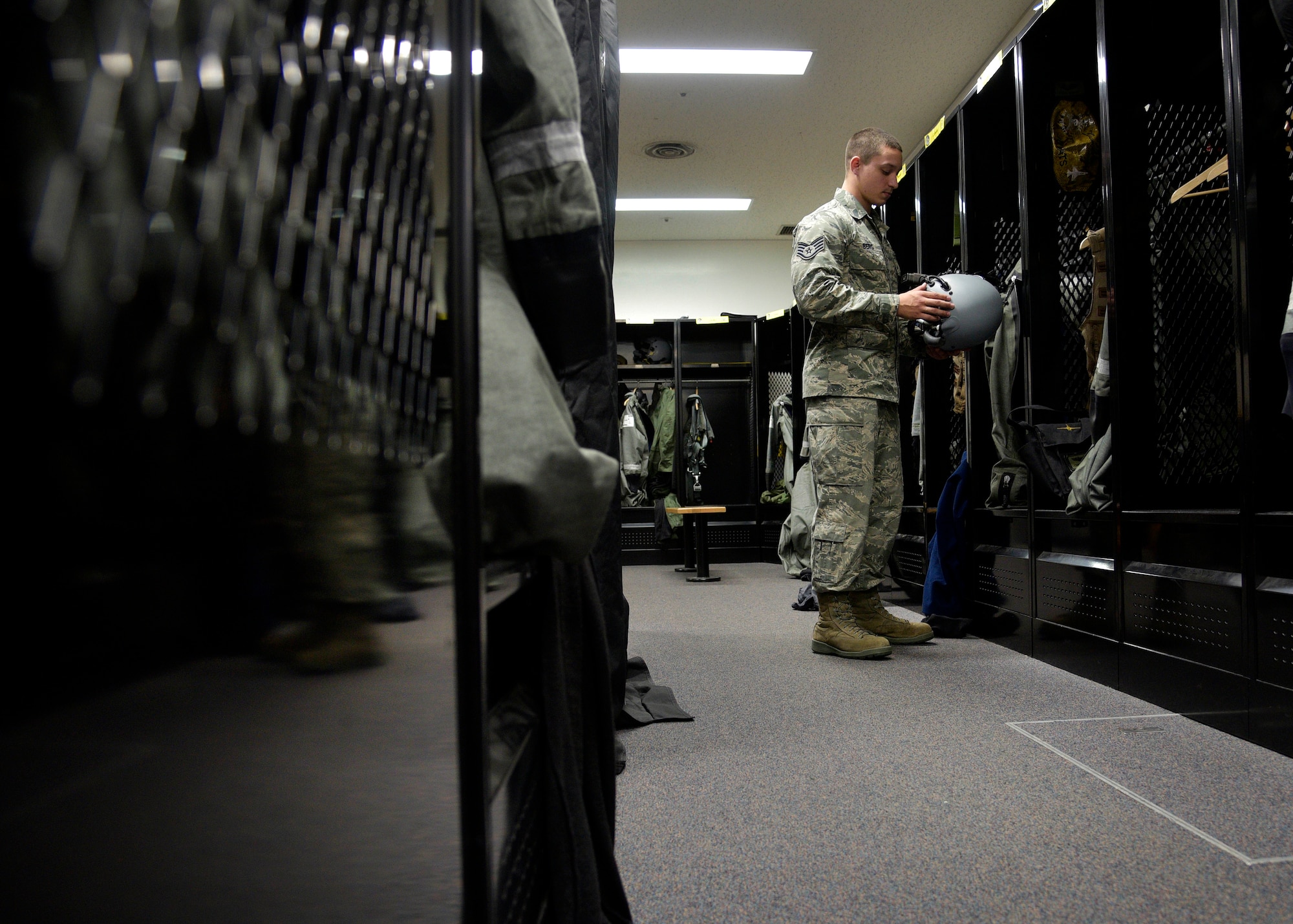 U.S. Air Force Staff Sgt. James Berg, an aircrew flight equipment craftsman with the 35th Operations Support Squadron, places a Joint Helmet Mounted Cueing System helmet inside a pilot’s locker at Misawa Air Base, Japan, March 8, 2016. Daily, AFE Airmen inspect all equipment used by Wild Weasel pilot during flight; ensuring each piece of equipment is fully operational and safe. (U.S. Air Force photo by Senior Airman Deana Heitzman)