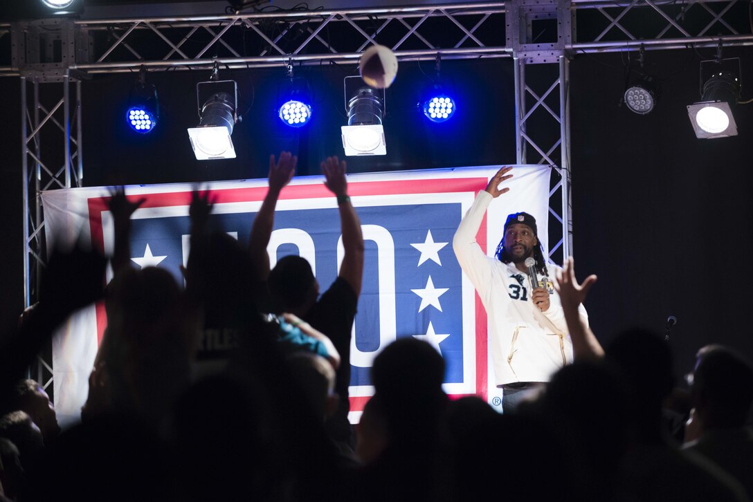 Pro football player Charles Tillman tosses a football to troops and family members during the USO spring entertainment tour on Camp Hansen, Japan, March 13, 2016. DoD photo by Army Staff Sgt. Sean K. Harp