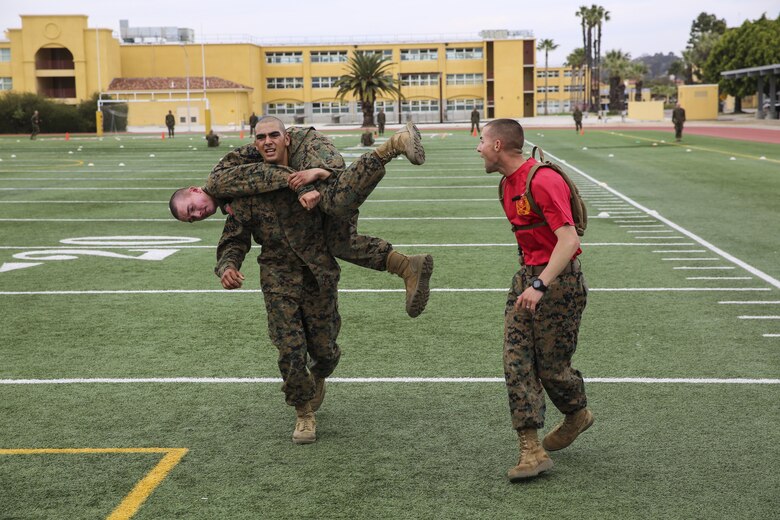 A recruit of Delta Company, 1st Recruit Training Battalion, conducts the fireman’s carry with a fellow recruit during the maneuver-under-fire portion of the Combat Fitness Test at Marine Corps Recruit Depot San Diego, March 10. The course for this portion covers 75 yards and requires recruits to perform exercises such as sprints, ammunition can carries, fireman’s carry and throwing a simulated grenade at a marked target. Recruits were timed as they ran through the course and needed to finish it in less than 2 minutes and 14 seconds for maximum points.  Annually, more than 17,000 males recruited from the Western Recruiting Region are trained at MCRD San Diego. Delta Company is scheduled to graduate April 1.