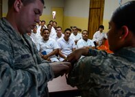 U.S. Air Force Senior Airman Jacob Radford and Staff Sgt. Karina Cortes, medical technicians stationed at Joint Base Charleston, S.C., demonstrate how to apply a tourniquet to medical technicians in training at Hospital Militar de El Salvador during a medical subject matter expert exchange in San Salvador, El Salvador, March 11, 2016. Earlier in the week, Carey led a team of Air Force medical professionals in a week-long exchange with Salvadoran medics at Ilopango Air Base. After the subject matter expert exchange was completed, the team was invited to a share their expertise with members of the Hospital Militar de El Salvador. (U.S. Air Force photo by Tech. Sgt. Heather R. Redman/Released)