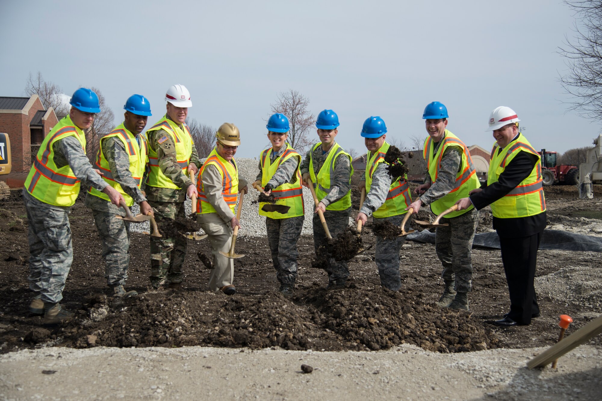 Participants of the Visitors Quarters groundbreaking toss a shovel-full of dirt to signify the beginning of construction March 11, 2016, at Scott Air Force Base, Ill. The building will replace the Scott Inn on Scott Drive. The six-story building will have 284 rooms, a 142-stall parking lot, 17 suites, conference rooms, a fitness facility, and a coffee shop. (U.S. Air Force photo/Senior Airman Jake Eckhardt)