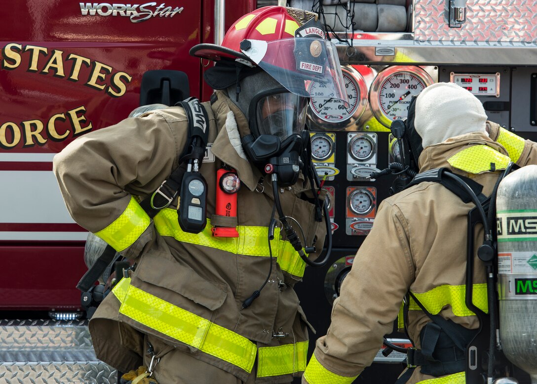 U.S. Air Force firefighters, assigned to the 633rd Civil Engineer Squadron, communicate how to extinguish a simulated fire during an aircraft crash exercise in Hampton, Va., March 10, 2016. All emergency responders executed the plan effectively by extinguishing the burning aircraft in less than two hours. (U.S. Air Force photo by Airman 1st Class Derek Seifert)