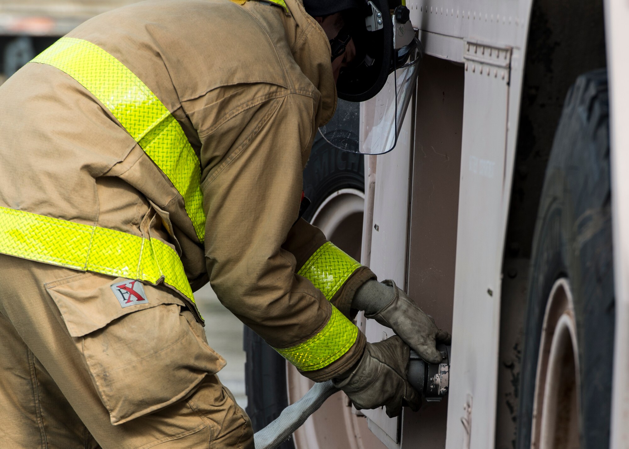A U.S. Air Force firefighter assigned to the 633rd Civil Engineer Squadron, attaches a hose to a P-19 crash truck during an exercise in Hampton, Va., March 10, 2016. The crash truck has been in use since the 1980s by Air Force firefighters and  rapidly deploys agents to an aircraft crash site  (U.S. Air Force photo by Airman 1st Class Derek Seifert)