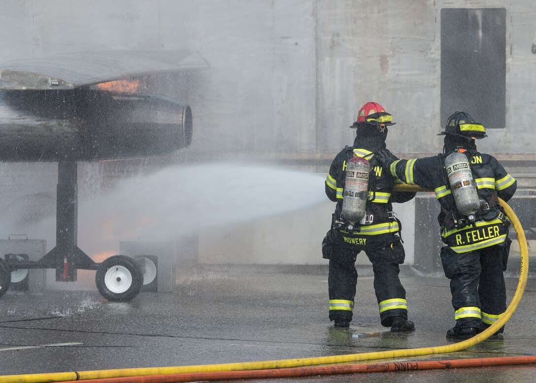 Hampton Division of Fire Rescue firefighters extinguish a simulated aircraft crash fire during an exercise in Hampton, Va., March 10, 2016. Langley Air Force Base firefighters and Security Forces assisted local first responders, Sentara Healthcare Center and Thomas Nelson Community College during the exercise to evaluate procedures and checklists to ensure they would be prepared if a real-world incident were to occur. (U.S. Air Force photo by Airman 1st Class Derek Seifert)