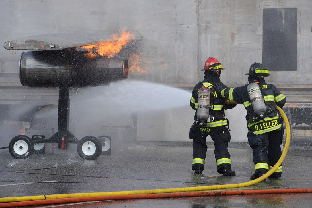 Hampton Division of Fire and Rescue firefighters put out a fire during a simulated F-22 Raptor crash exercise in Hampton, Va., March 10, 2016. The exercise was staged at Thomas Nelson Community College in order to evaluate the procedures for an off-base mishap. (U.S. Air Force photo by Senior Airman Brittany E. N. Murphy)