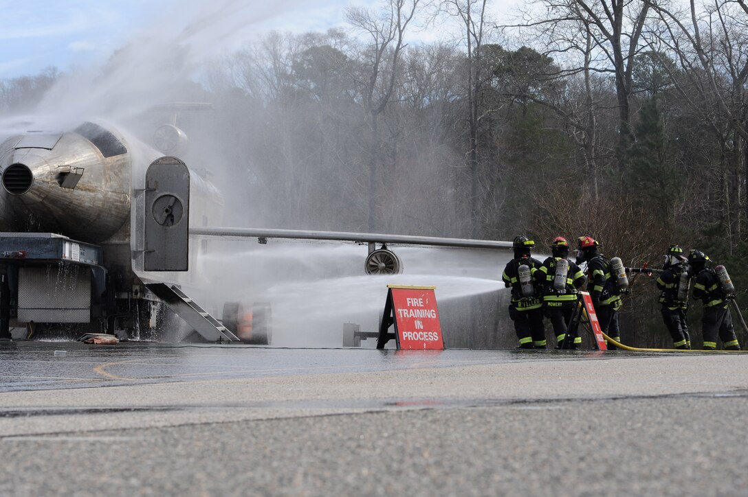 Hampton Division of Fire and Rescue firefighters participate in a joint exercise which simulated an F-22 Raptor crash in Hampton, Va., March 10, 2016. The two-day exercise included putting out an aircraft fire as well as the Langley Search and Rescue team performing a simulated search of remains and debris. (U.S. Air Force photo by Senior Airman Brittany E. N. Murphy)