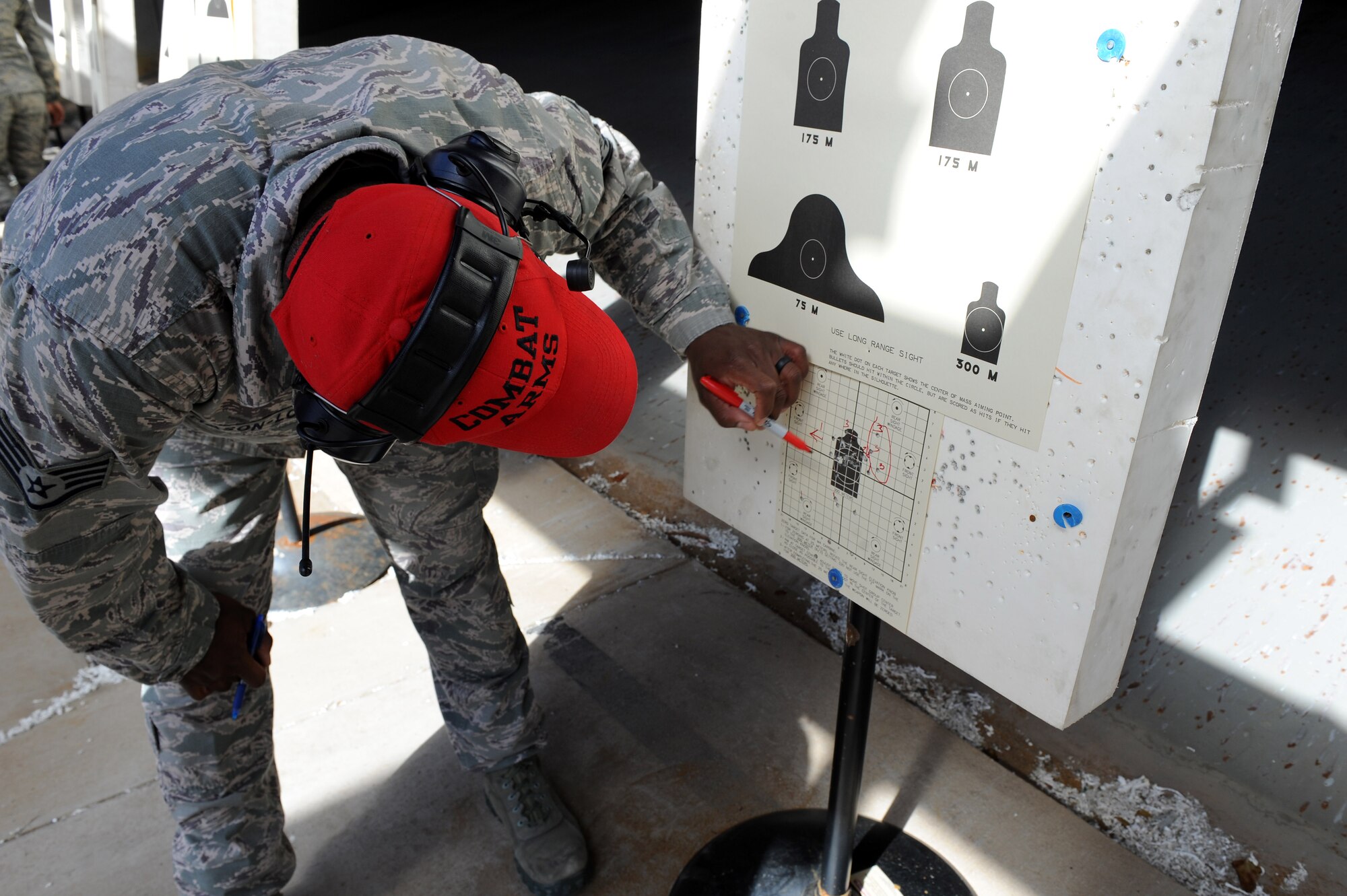 U.S. Air Force Staff Sgt. Michael Mason-Love, combat arms instructor assigned to the 633rd Security Forces Squadron, marks holes on a M-4 Carbine target at Langley Air Force Base, Va., March 8, 2016. Combat arms instructors mark where the shooters hit and keep score as the shooter moves through each portion of the qualification. (U.S. Air Force photo by Senior Airman Brittany E. N. Murphy)