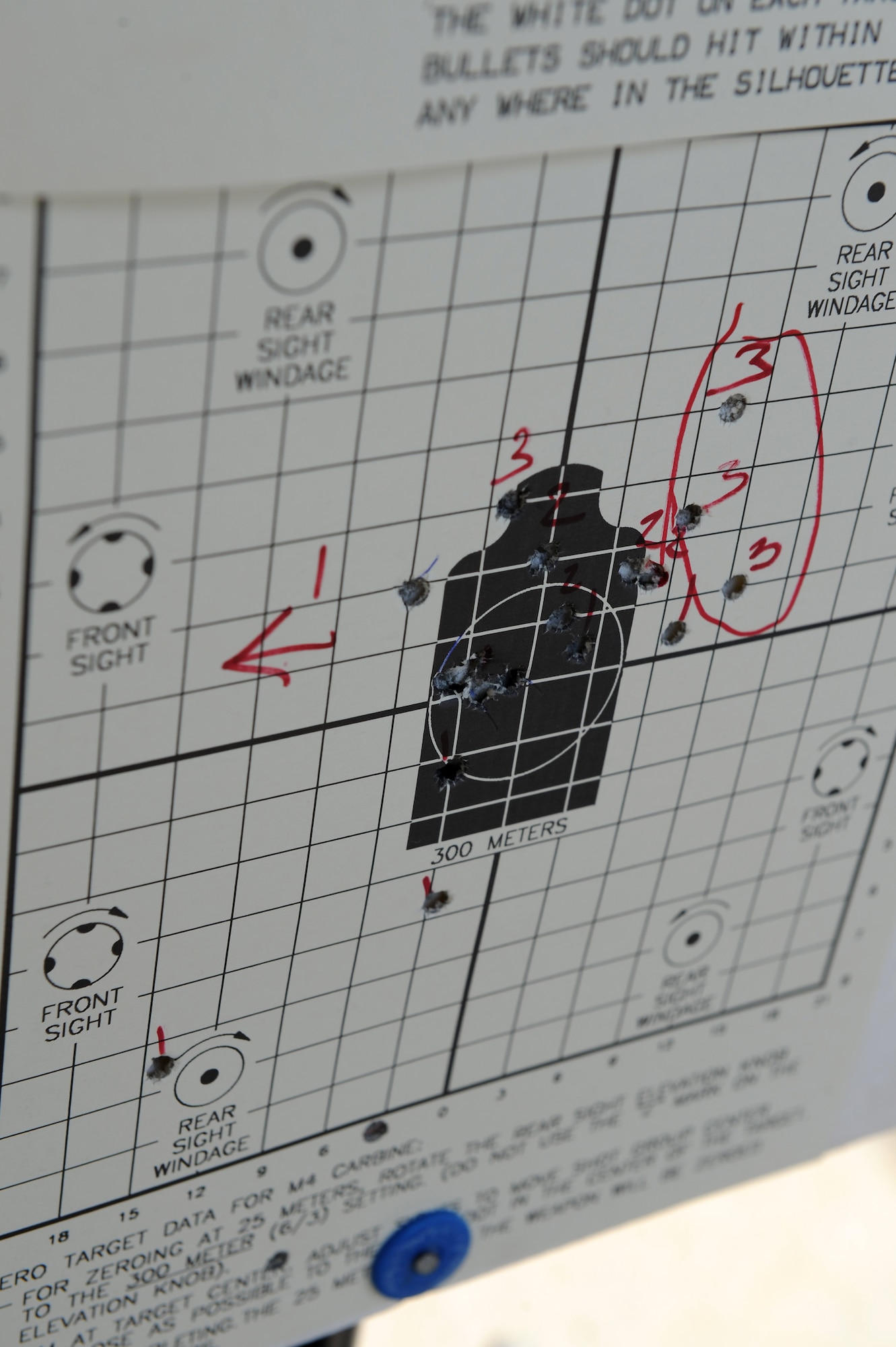 An M-4 Carbine target is marked for adjustments during a qualification course at Langley Air Force Base, Va., March 8, 2016. Combat arms instructors mark where the target was hit to help make adjustments to the sights of the weapon so that the shooter can achieve a proper zero. (U.S. Air Force photo by Senior Airman Brittany E. N. Murphy)
