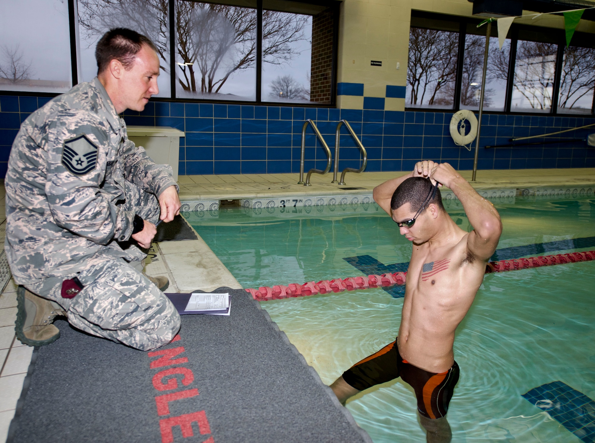U.S. Air Force Master Sgt. Travis Shaw, the pararescue medical program manager at Air Combat Command, instructs Senior Airman D’Vonte Washburn, an aircraft maintenance scheduler with the 1st Maintenance Group, on swim time requirements for the Physical Aptitude Stamina Test (PAST) at Langley Air Force Base, Va., March 3, 2016. To be considered for cross training into a battlefield Airmen career field, candidates must pass all exercises in the PAST. Eight years ago, Shaw cross trained into the pararescue career field and now helps possible candidates achieve their dreams of becoming a battlefield Airman. (U.S. Air Force photo by Airman 1st Class Derek Seifert)