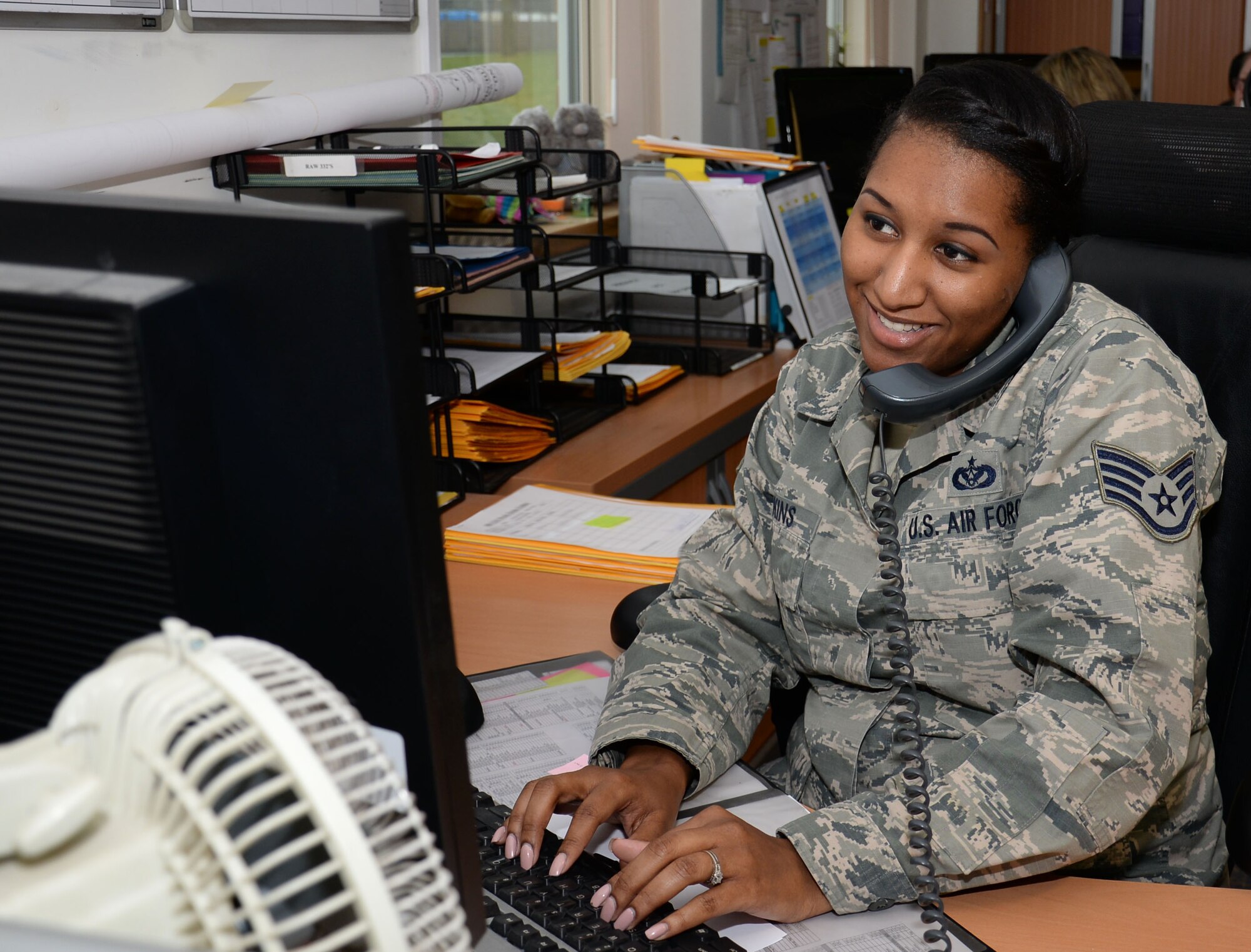 U.S. Air Force Staff Sgt. Diamond Wilkins, 100th Civil Engineer Squadron requirements and optimization section craftsman, speaks with a facility manager about a work request March 9, 2016, on RAF Mildenhall, England. Commanders appoint a facility manager to take care of their buildings; Wilkins and her team take care of all the facility managers on base. (U.S. Air Force photo by Gina Randall/Released)