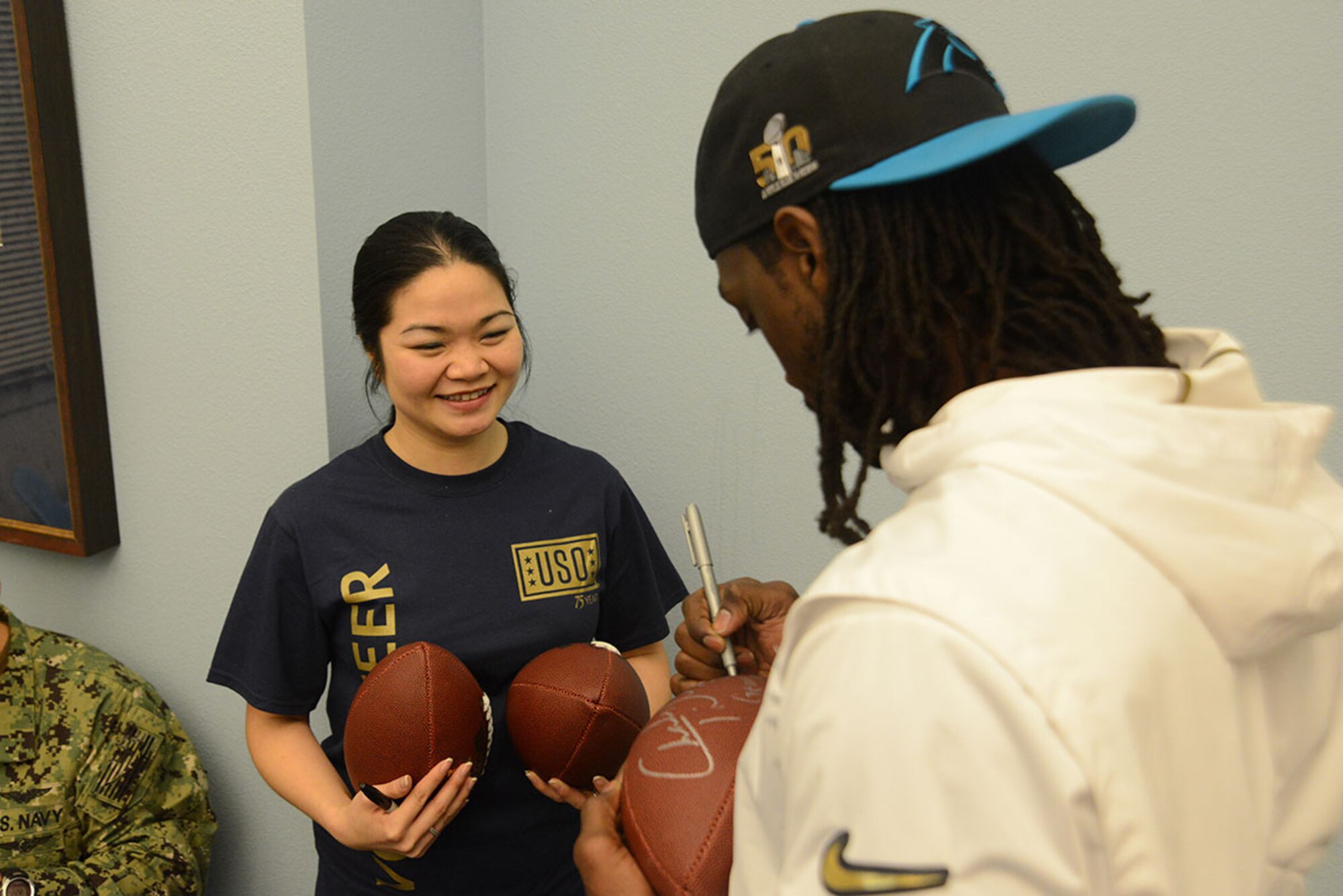 Carolina Panthers football player Charles Tillman signs several footballs for a USO volunteer at the Joint Base Elmendorf-Richardson USO pancake breakfast as part of the USO Spring 2016 Entertainment Tour March 12, 2016. Air Force Gen. Paul Selva, 10th Vice Chairman of the Joint Chiefs of Staff led the tour also featuring Miss America Betty Cantrell, country singer and 10-year Army veteran Craig Morgan, and Ultimate Fighting Championship fighters Anthony Pettis and Donald ‘Cowboy’ Cerrone. (U.S. Air Force photo by Airman 1st Class Christopher R. Morales)