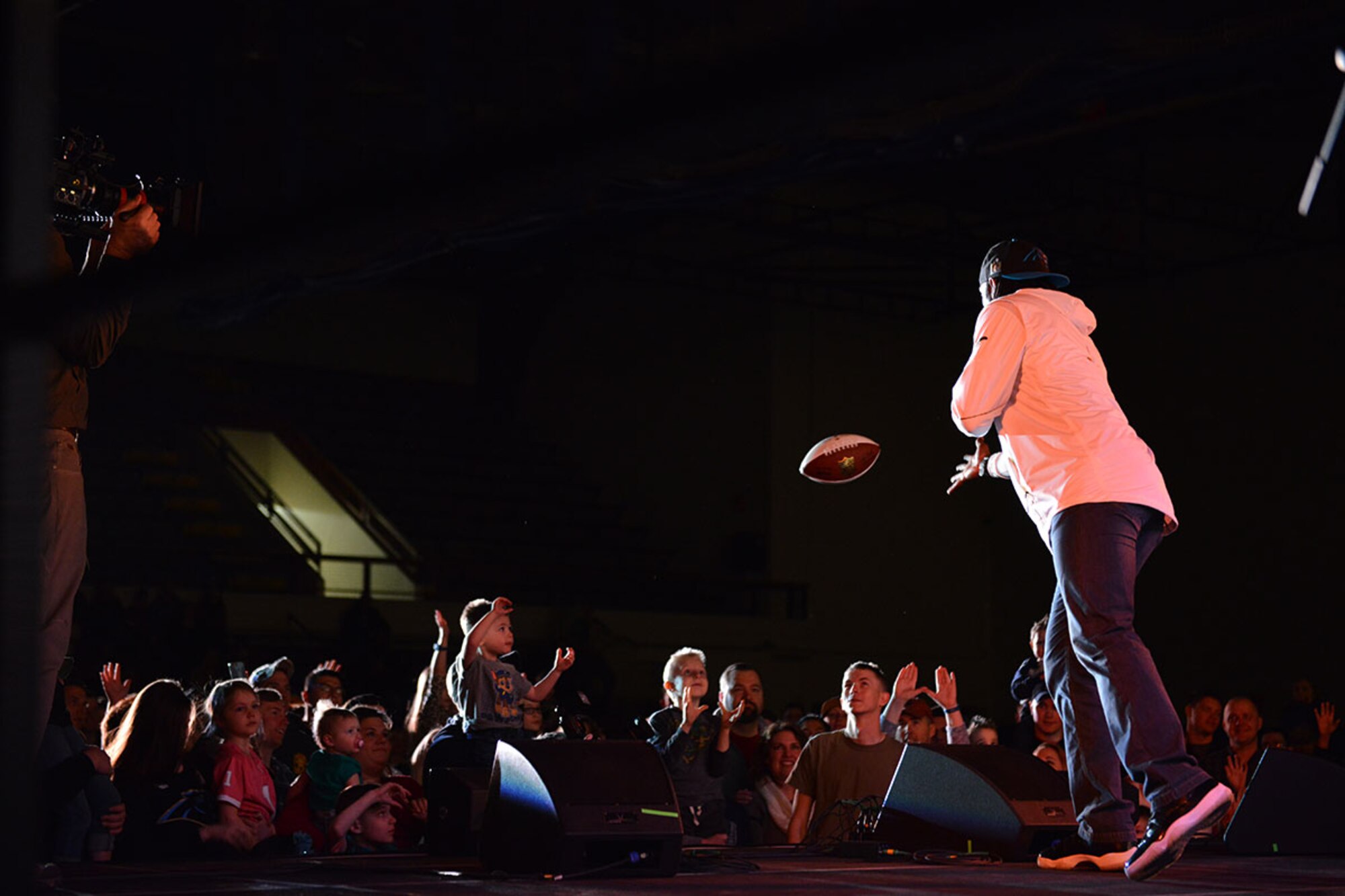 North Carolina Panthers football player Charles Tillman throws a football into the crowd at the USO Spring 2016 Entertainment Tour featuring Miss America Betty Cantrell, country singer and 10-year Army veteran Craig Morgan and Ultimate Fighting Championship fighters Anthony Pettis and Donald ‘Cowboy’ Cerrone at Joint Base Elmendorf-Richardson March 12. The tour was led by Air Force Gen. Paul Selva, 10th Vice Chairman of the Joint Chiefs of Staffs, who used this as an opportunity to visit Arctic Warriors. (U.S. Air Force photo by Airman 1st Class Kyle Johnson)
