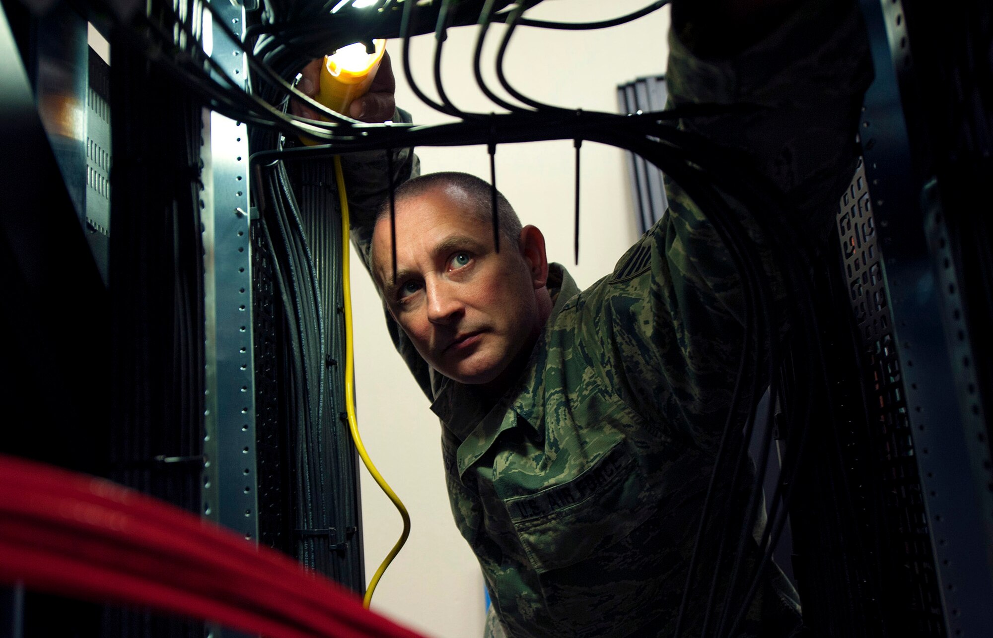 Tech. Sgt. Jeremy Nagy, 270th Engineering Installation Squadron, Range Simulation Center Installer, inspects a cabinet of recently installed cables March 2, 2016, Vandenberg Air Force Base, Calif. Nagy is part of an Air National Guard EI team working on a relocation of the Launch and Test Range System for the Western Range. (U.S. Air Force photo by Michael Peterson/released)